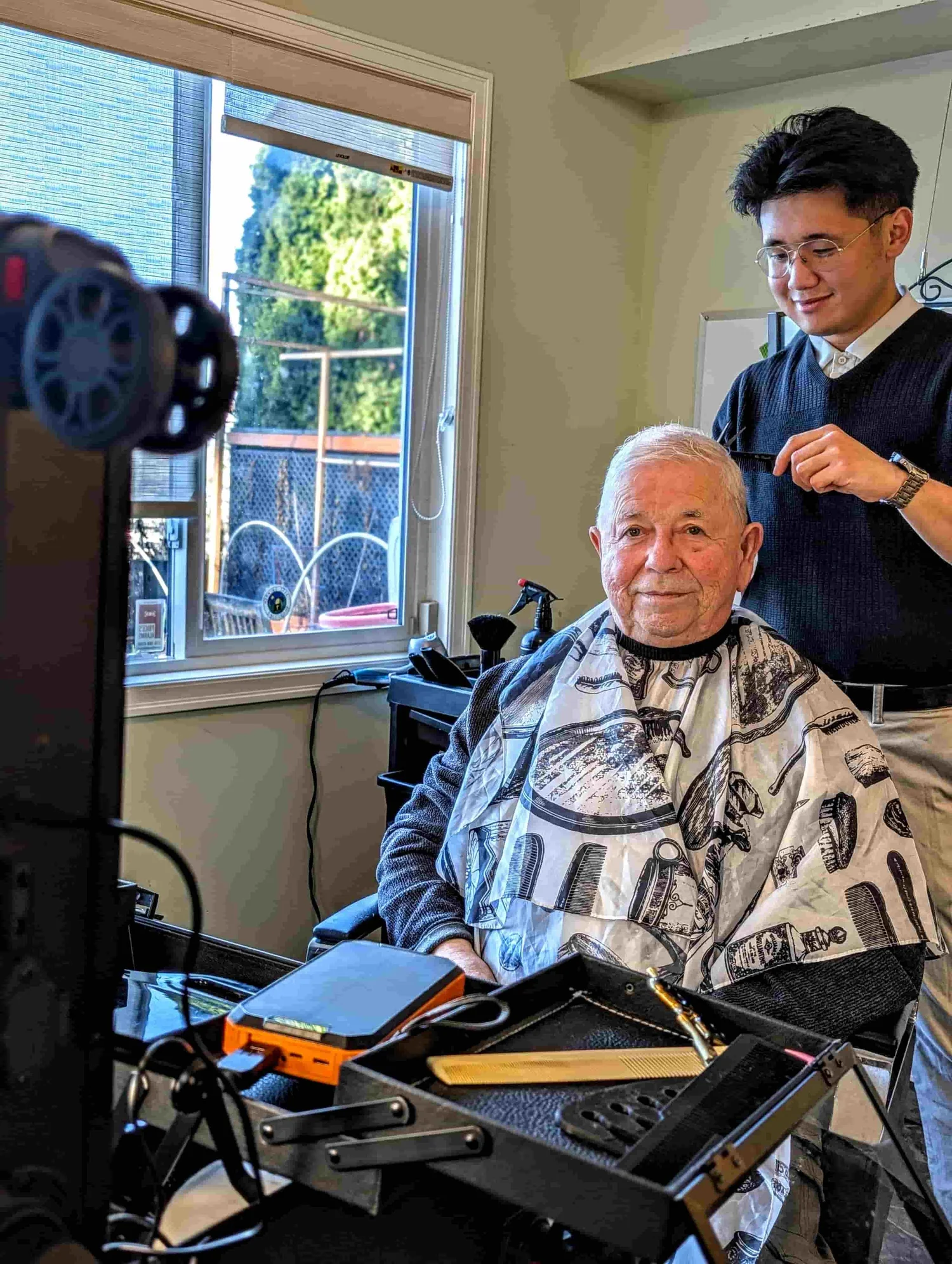 Danny giving a senior a mobile haircut at home in Greater Victoria with his portable barber kit